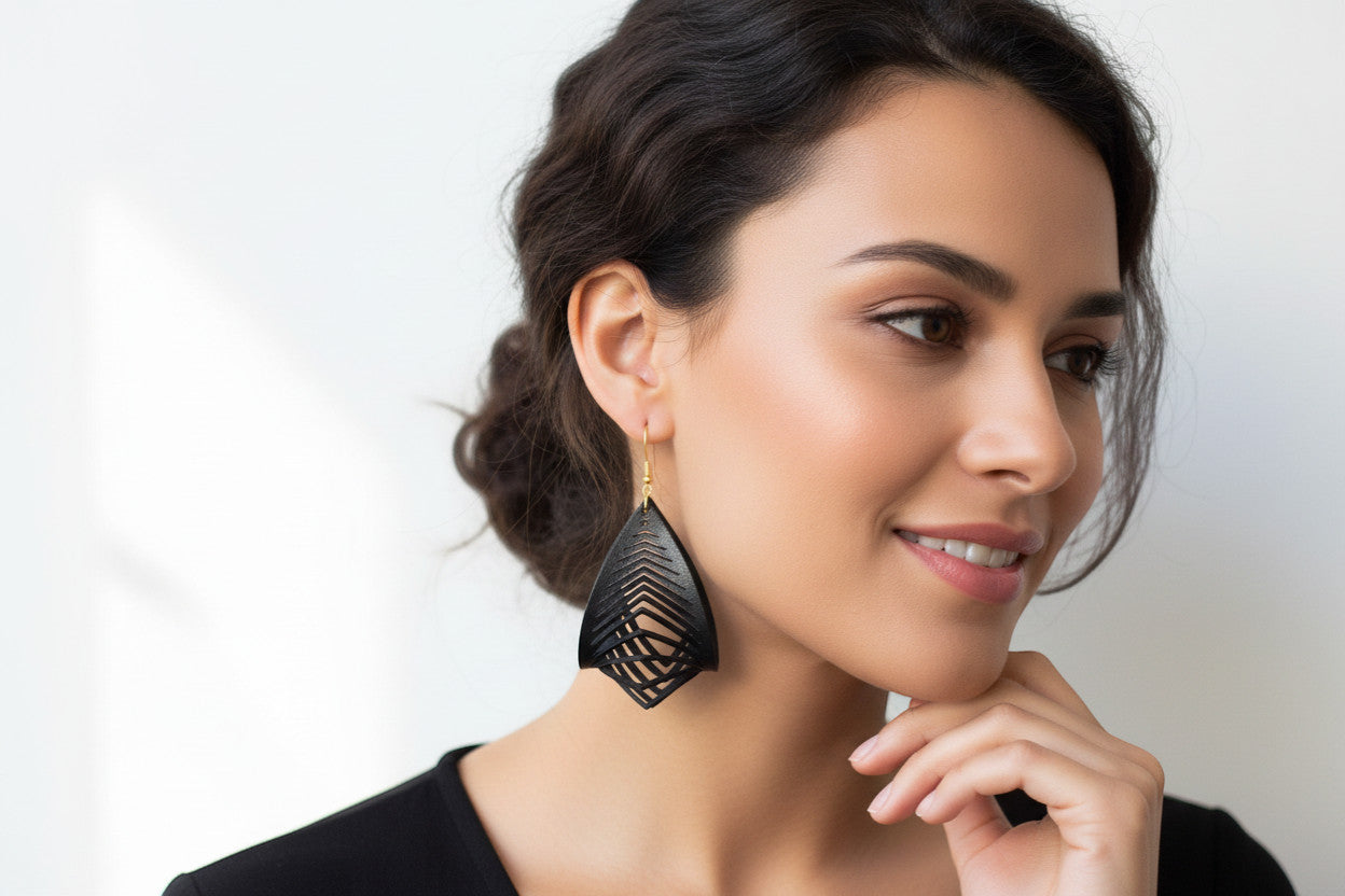 Rejecting Retail Studio hand-painted black leather statement earrings with gold accents and 3D sculpted design.