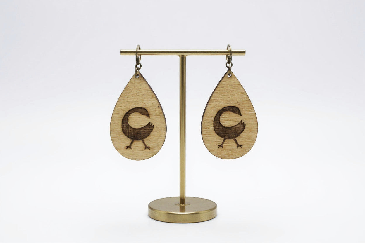 Rejecting Retail Studio Sankofa symbol engraved birchwood teardrop earrings with art deco border. Lightweight artisan jewelry.