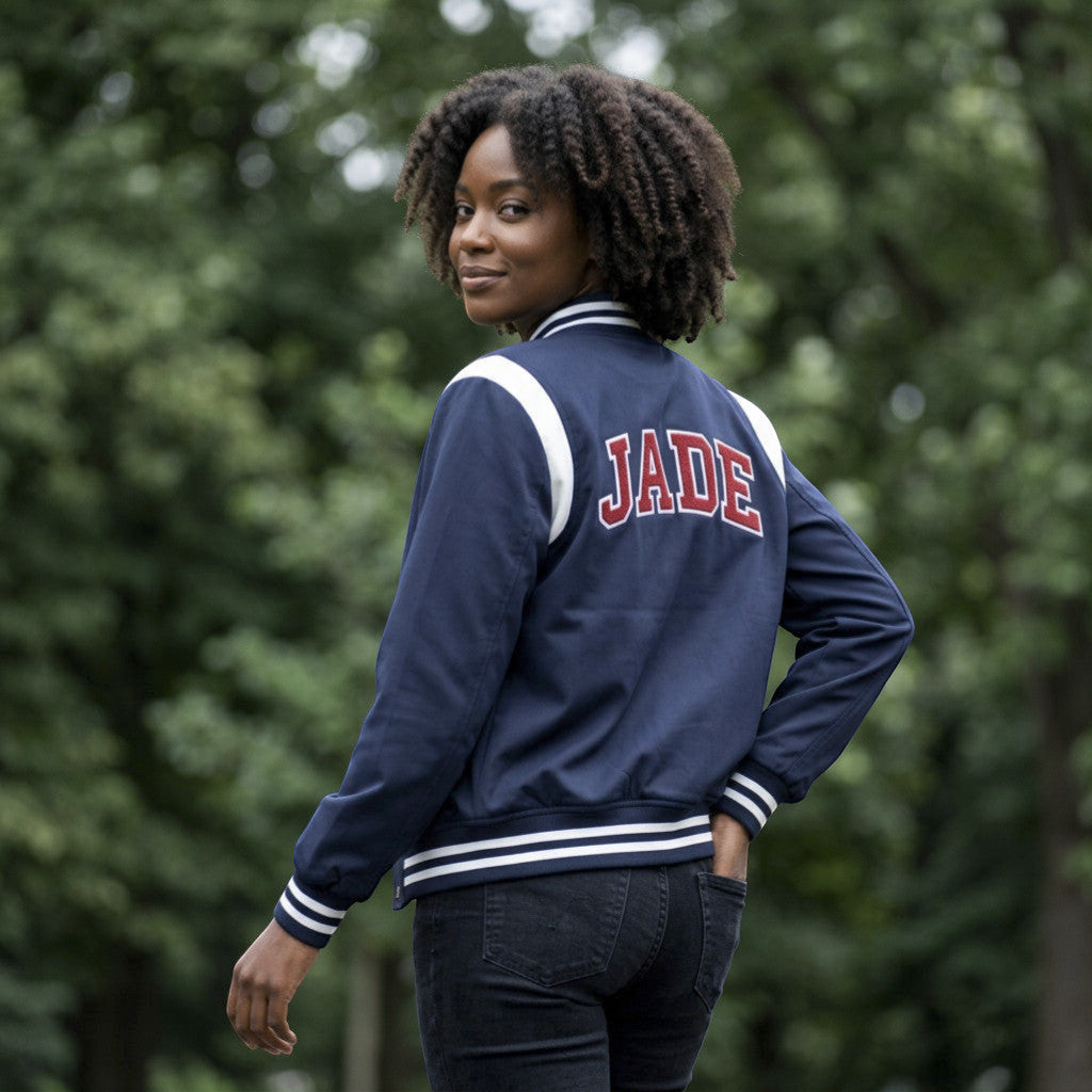 Rejecting Retail Studio navy blue custom embroidered varsity jacket with white stripes and red lettering spelling JADE.