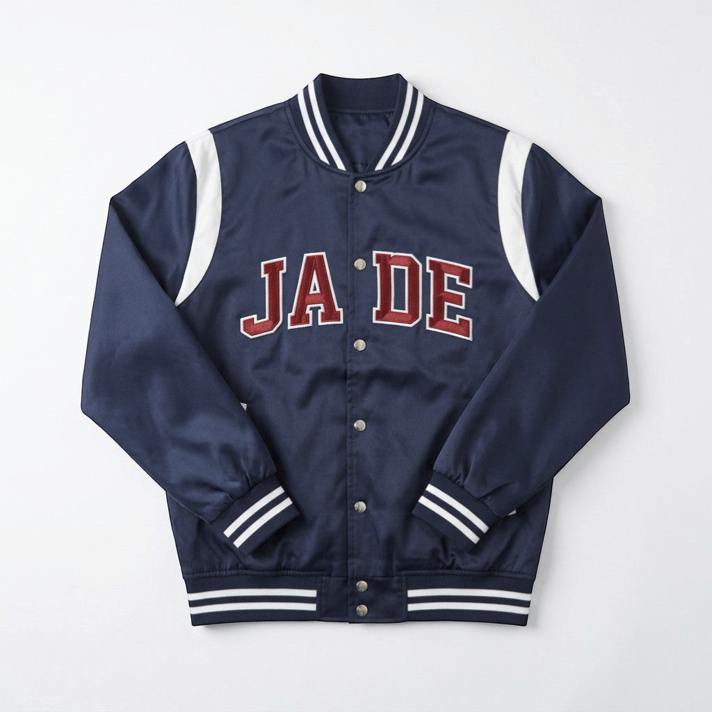 Rejecting Retail Studio navy blue satin varsity jacket with custom red embroidered letters and white accents on shoulders and cuffs.