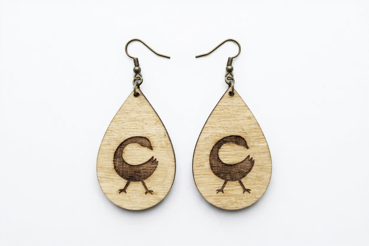 Rejecting Retail Studio Sankofa symbol engraved birchwood teardrop earrings with art deco border. Lightweight artisan jewelry.