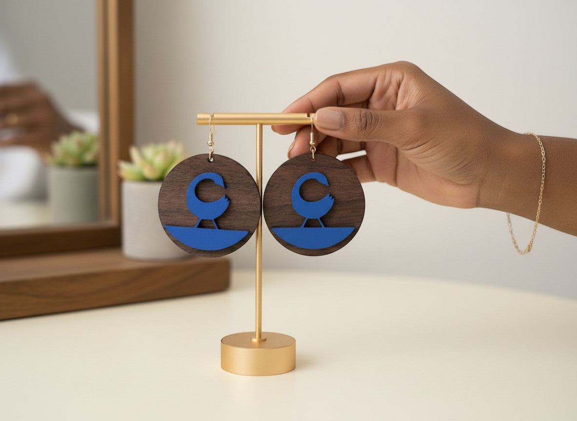 Rejecting Retail Studio walnut wood and cobalt blue leather Sankofa earrings. Laser-carved Sankofa symbol on wood with leather accent.