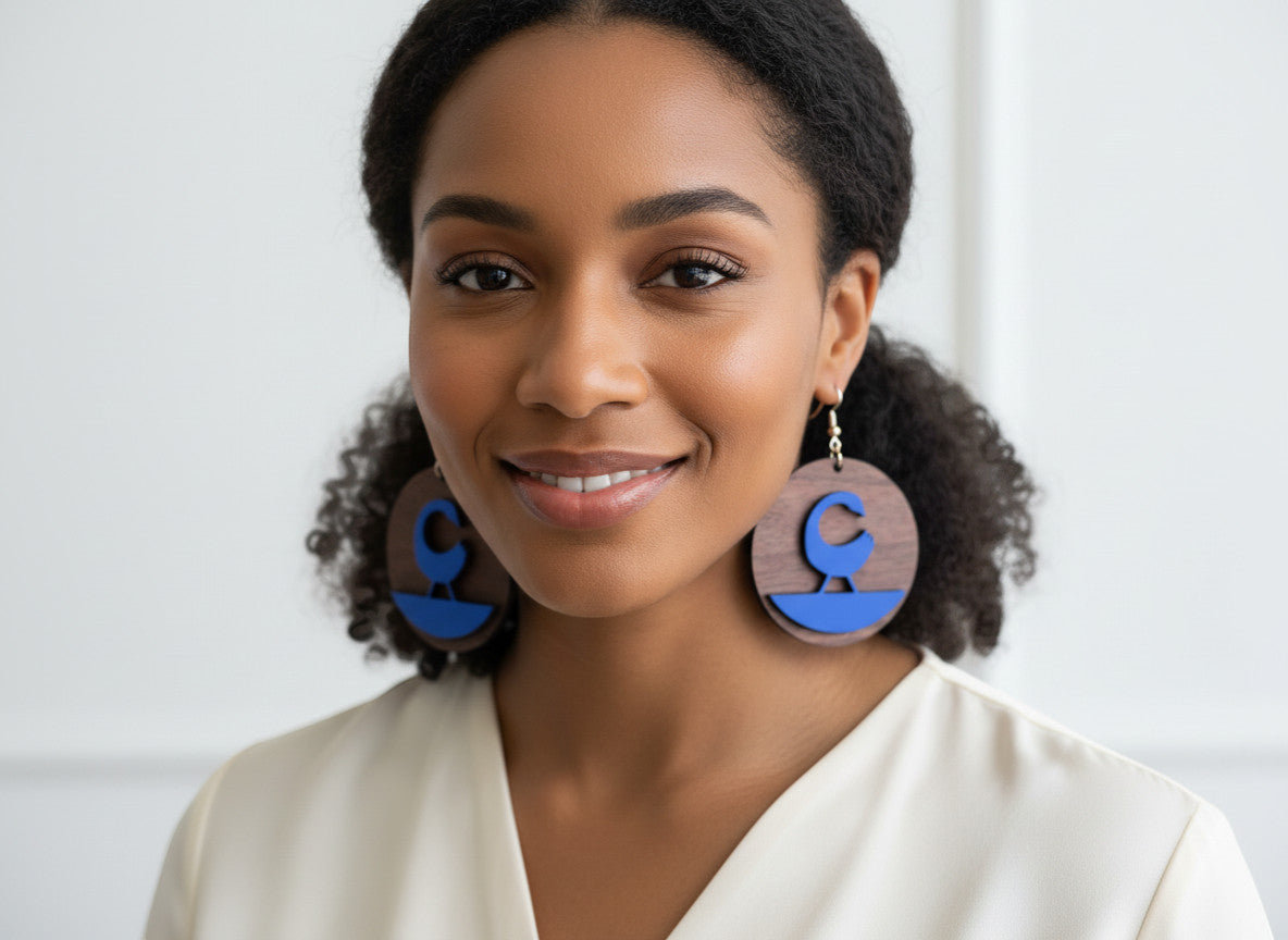 Rejecting Retail Studio walnut wood and cobalt blue leather Sankofa earrings. Laser-carved Sankofa symbol on wood with blue leather accent.