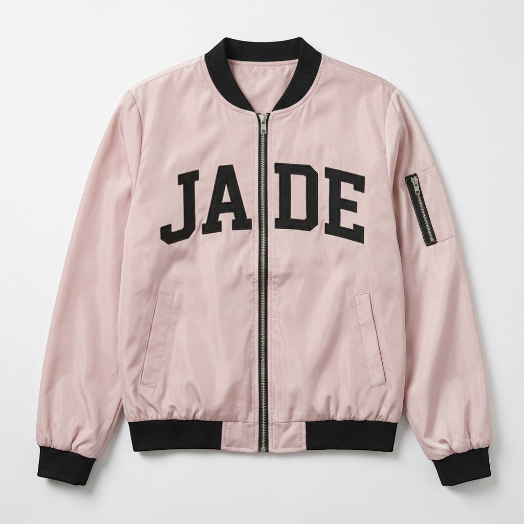 Rejecting Retail Studio pink zip-up varsity bomber jacket with black embroidered "JADE" text and black trim.